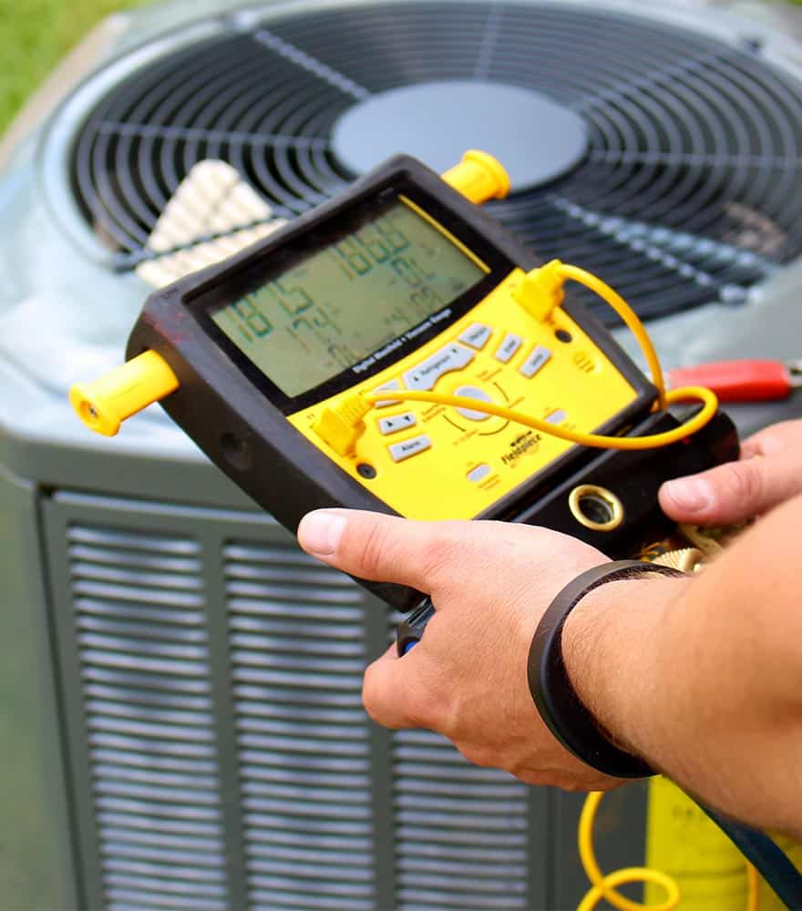 A technician tests an AC unit