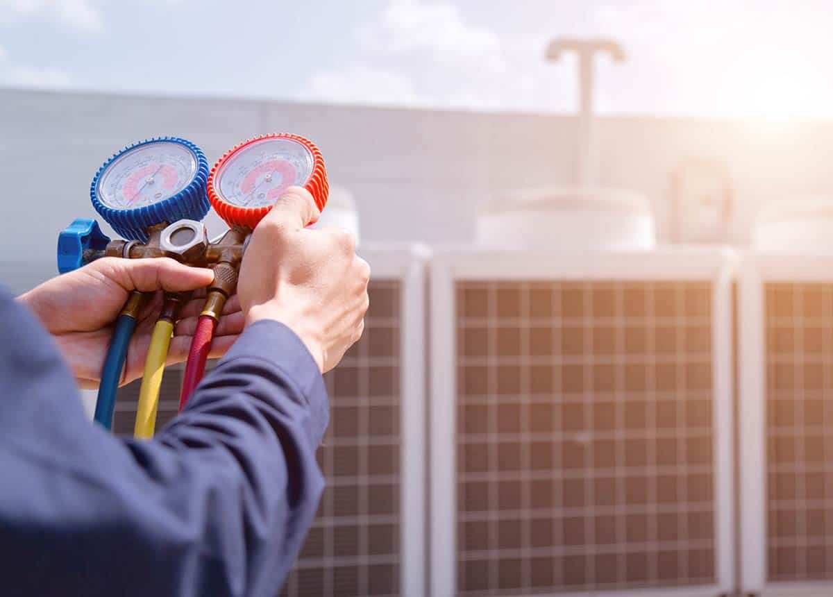 A technician checking a rooftop unit