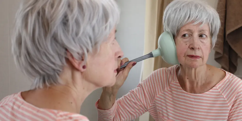A woman holding a sink plunger to her ear